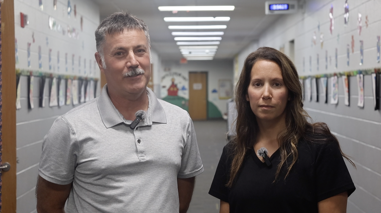 Principals stand in an empty hallway